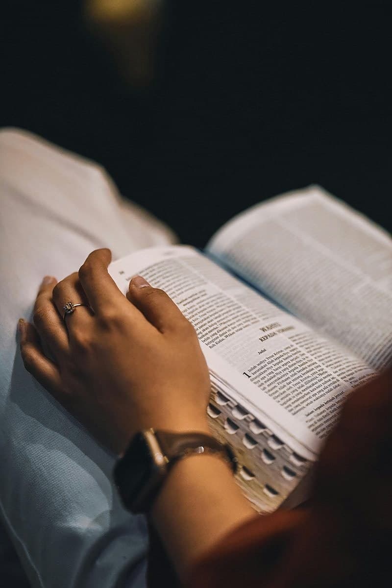 Hands resting on an open Bible