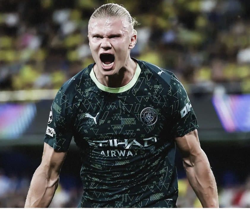 Erling Haaland shouting in celebration in a Manchester City shirt