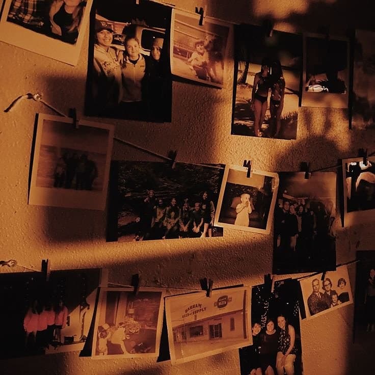A wall of pinned photographs and polaroids